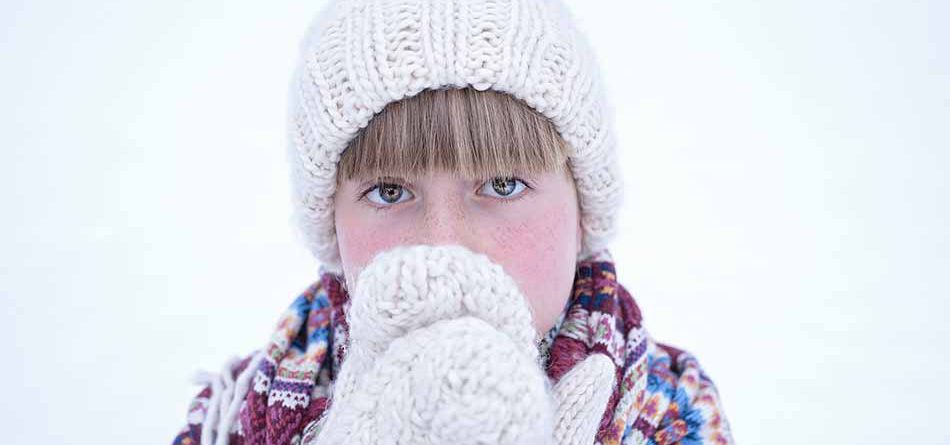 Enfant avec la peau des joues rouge du au froid.